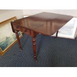 A Victorian mahogany drop leaf table on turned supports.