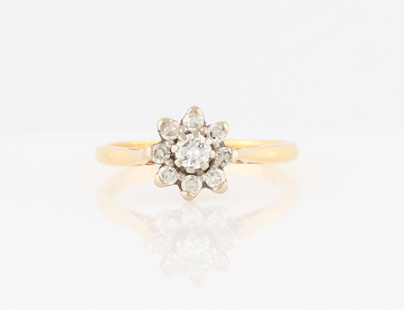 An 18ct yellow gold diamond flower design ring, set with a central round brilliant cut diamond