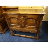 A reproduction distressed oak cupboard fitted two doors, one drawer below on turned supports.