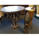 An African hard top table with four characters to base, animal skin cylinder drum and African