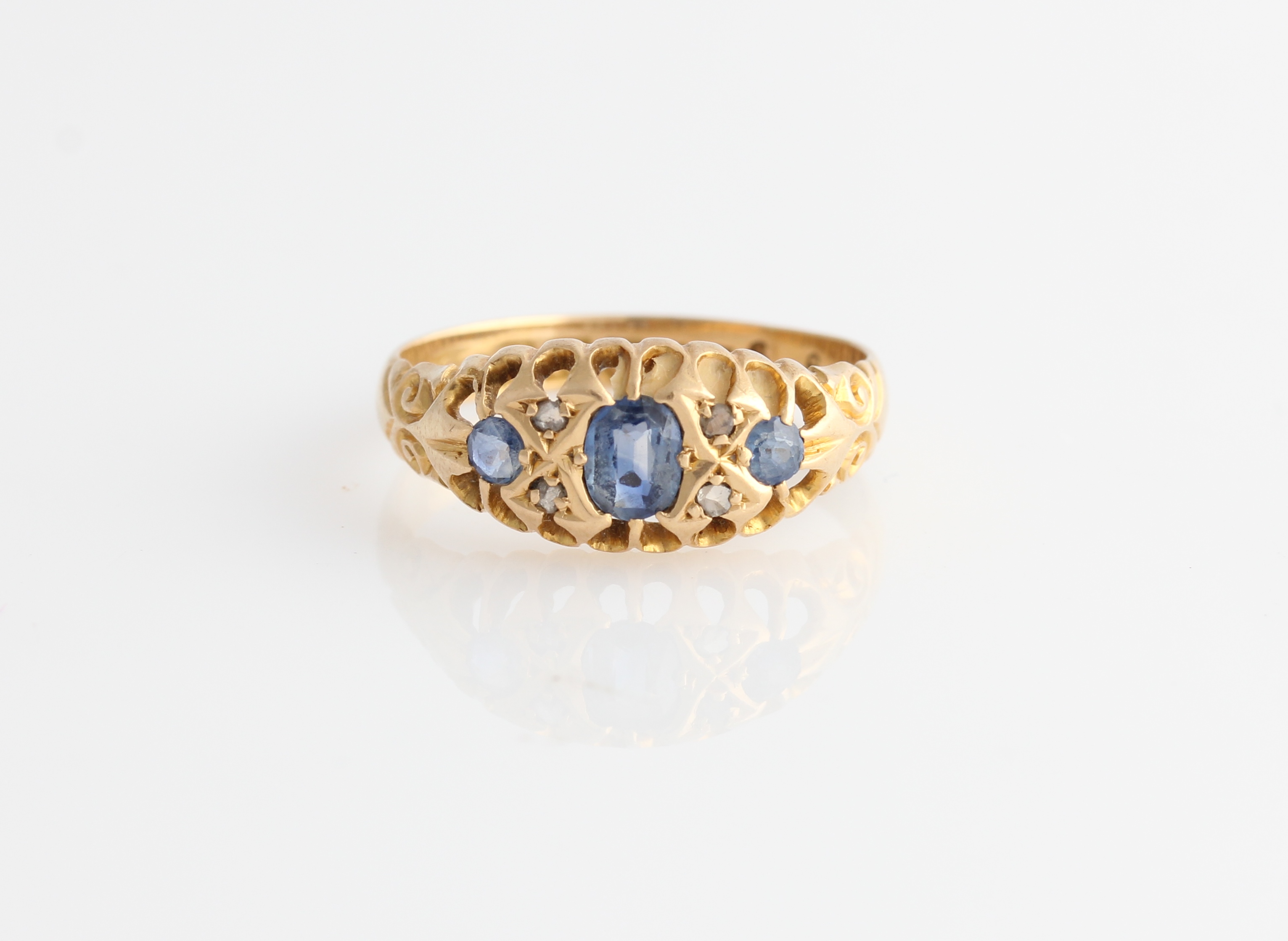 An 18ct yellow gold sapphire and diamond ring, set with three principal sapphires and four diamond