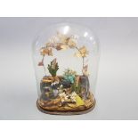 A Victorian garden display including flowers, figures under glass dome.