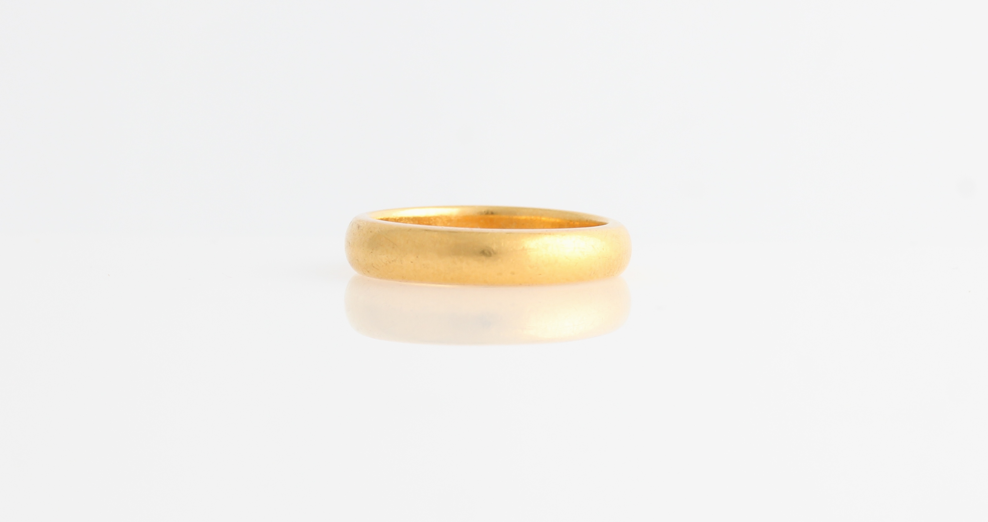 A 22ct yellow gold wedding band of plain design, hallmarked Birmingham 1915.