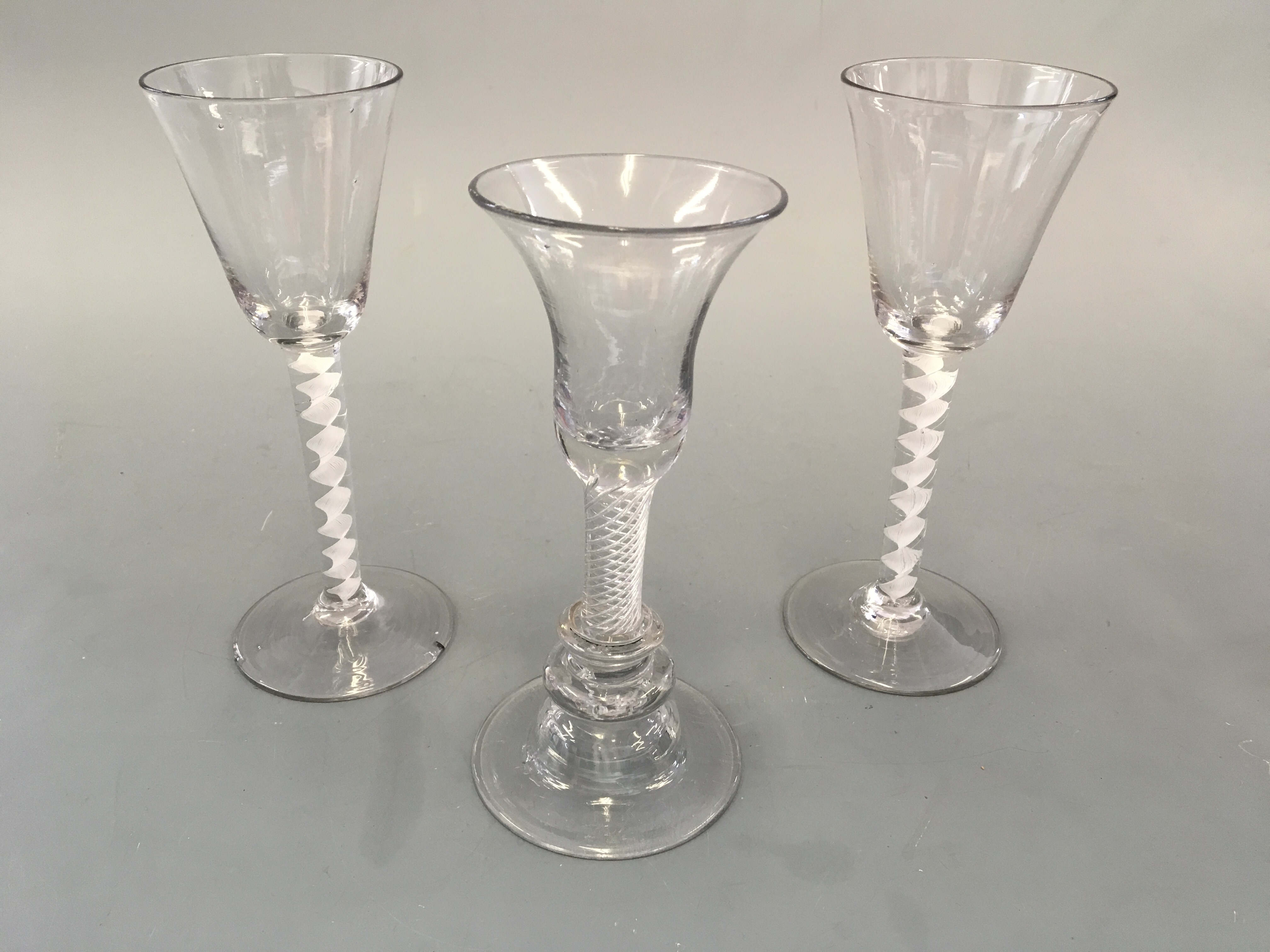 Three glasses, one with air twist and two with opaque twist stems. Heights 17cm and 18cm.