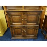 A reproduction distressed oak four door storage cupboard.