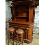 A mahogany bar with built in fridge, large shelf back and two bar stools.