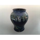 A Moorcroft Moonlit Blue bulbous vase, light blue on dark blue background, with signature to base.