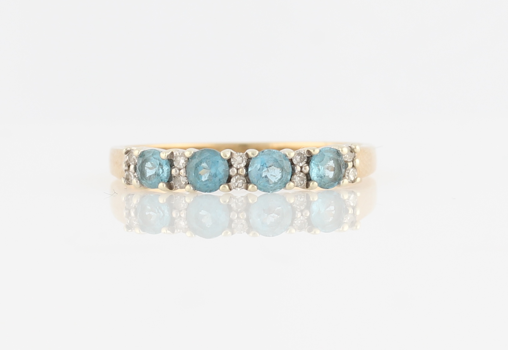 A hallmarked 9ct yellow gold aquamarine and diamond half eternity ring, the four round cut