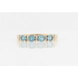 A hallmarked 9ct yellow gold aquamarine and diamond half eternity ring, the four round cut