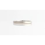 A white metal wedding band of plain design, stamped PLATINUM.