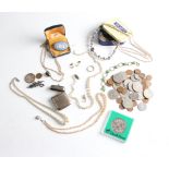 A collection including various coins, including commemorative coins, glass beads, a lobster clasp
