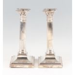 A pair of silver weighted column candlesticks, hallmarked London 1905, makers mark T.B, height