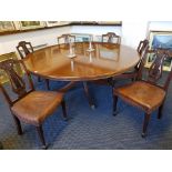 A large reproduction circular mahogany dining table on circular base and six lyre back chairs.