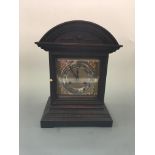 An oak cased mantel clock with brass detail to face. Height 37cm.
