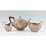 A three piece silver tea set, comprising a tea pot, sugar bowl and milk jug, all hallmarked