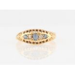 An 18ct yellow gold sapphire and diamond boat ring, set with three round cut sapphires and two old