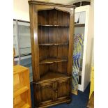 A reproduction oak floor standing corner cupboard, open shelf top and two doors below.