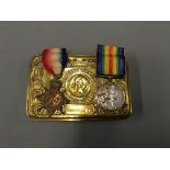 A 1914 Christmas brass tin containing two First World War medals.