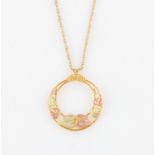 A 9ct two-tone gold pendant, of circular open metalwork design featuring leaves, hallmarked London