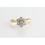 A diamond flower design ring, set with seven round brilliant cut diamonds, total diamond weight