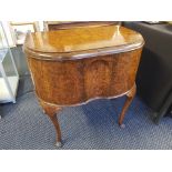 A burr walnut bow front, two door cabinet on Queen Anne style suports.