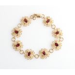 A 9ct yellow gold garnet bracelet, each articulated open metalwork link, set with oval cut garnet,