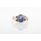 A diamond and sapphire three stone ring, set with a central oval cut sapphire, measures approx.