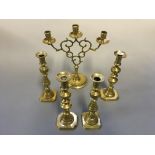 Two pairs of brass candlestick holders with one three branch candlestick holder.