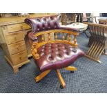 A reproduction swivel office elbow chair in leather upholstery with button back and seat.