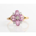 A hallmarked 9ct yellow gold pink sapphire and diamond dress ring, set with four oval cut pink