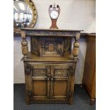 A reproduction distressed oak small court cupboard, fitted one small door to top, two fitted doors