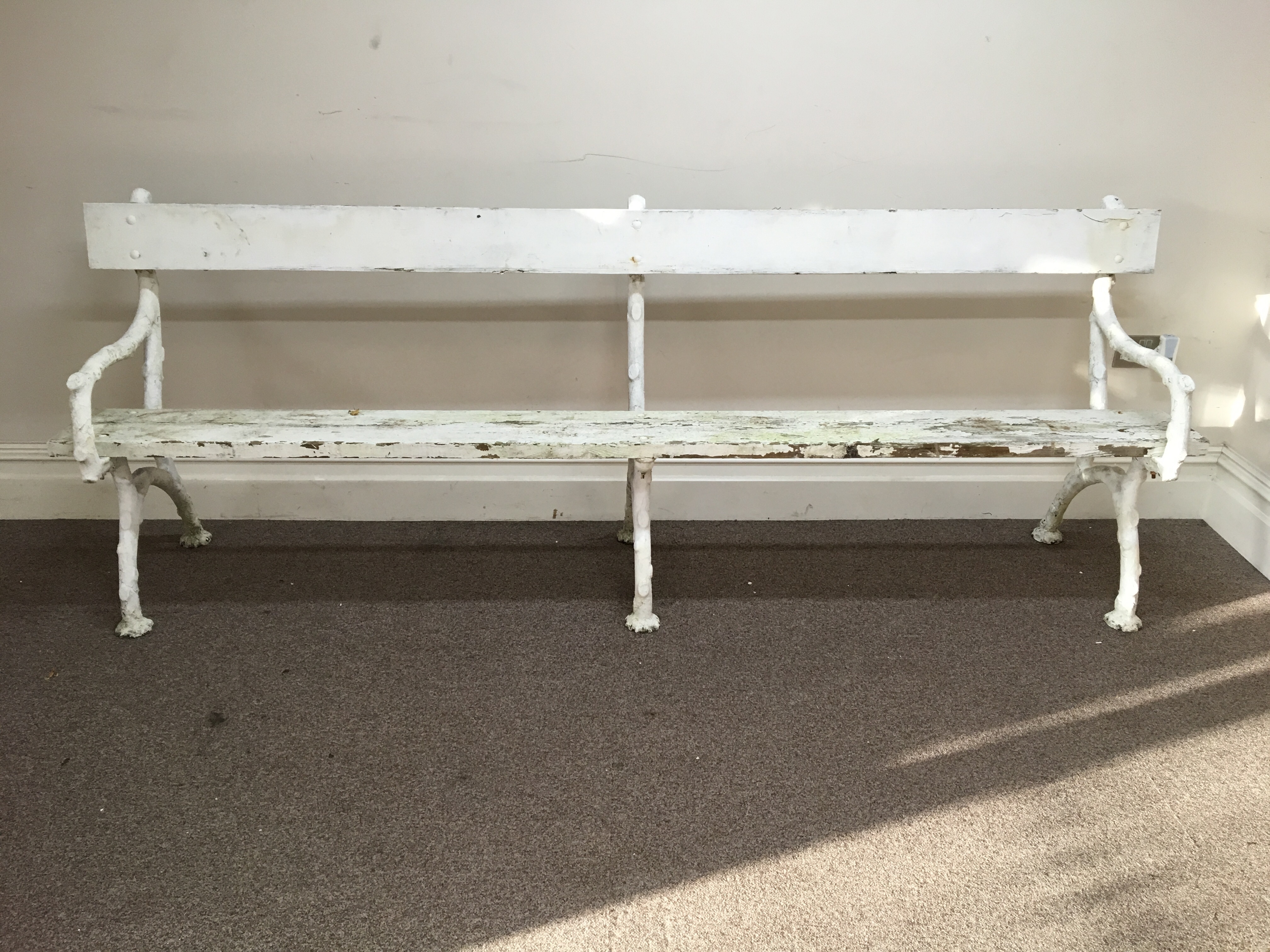 A white painted iron framed bench.
