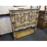 A reproduction distressed oak sideboard, fitted two doors, two drawers carved front on turned