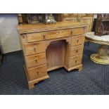 A pine writing desk with fold over top, knee hole fitted one long drawer, six small drawers and