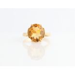 A citrine dress ring, set with an oval cut citrine, measuring approx. 12x10mm, indistinctly stamped,