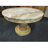 A circular marble top coffee table on central bulbous supports.