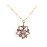 An amethyst and seed pearl star design pendant, set with a central round cut amethyst, surrounded by