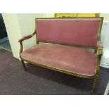 A gilt framed French salon settee with pink upholstery on turned supports.