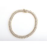 A hallmarked 9ct yellow gold, diamond line bracelet, each articulated link set with an eight-cut