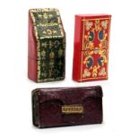 Three leather needle packet boxes comprising a green and red leather slant top example gilt