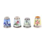 Four continental white metal thimbles decorated in enamels, one in the Delft style, one a bird,