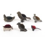 Six cast metal figural pin cushions, five in the form of birds, the other a standing pig, largest