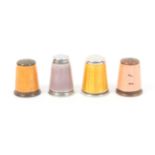 Four continental enamel decorated thimbles comprising a yellow enamel example with stone top,