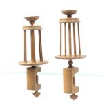 A pair of wooden winding clamps the book form bases supporting tapering cages below cup tops,