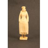 A Dieppe carved ivory fisherwoman needle case, traditional costume, hands in pockets, rectangular