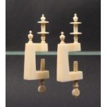 A pair of ivory winding clamps, circa 1820, the rectangular frames with turned urn form finials