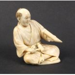 A 19th Century Japanese carved ivory figure of a seated man with mallet and post, inset red