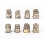 Eight American white metal and silver thimbles including three with homestead friezes and a cherub