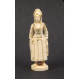 A Dieppe carved ivory standing needlecase in the form of a standing fisherwoman in traditional