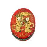 A papier mache chinoiserie style pin cushion, of oval form the red ground decorated to one side in